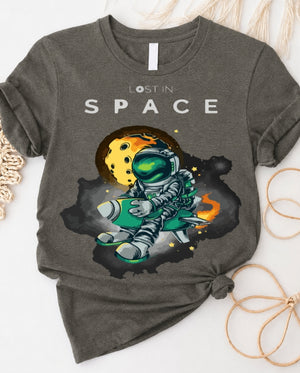 Space graphic t-shirt with astronaut floating through galaxy design front view