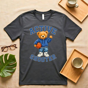 A person wearing a soft gray t-shirt with a vintage-style graphic of a bear wearing a sports headband, against a neutral background.