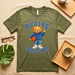 A person wearing a soft gray t-shirt with a vintage-style graphic of a bear wearing a sports headband, against a neutral background.