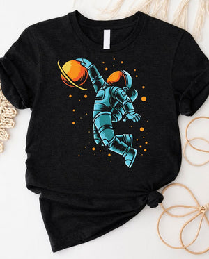 Astronaut playing basketball on moon surface graphic tee