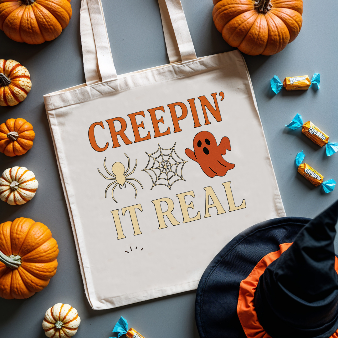 “Creepin’ It Real Halloween tote bag with ghost and spiderweb graphic”