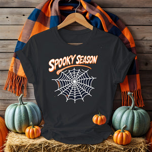 Funny Halloween T-shirt with “Spooky Season” print – black unisex jersey shirt flat lay with pumpkins and fall leaves