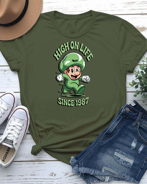 Funny High On Life meme T-shirt with bold typographic text, worn casually with a smile and relaxed posture.