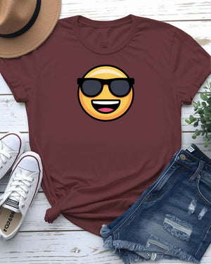 Funny emoji face wearing glasses printed in bold on a unisex t-shirt – shown on smiling model.
