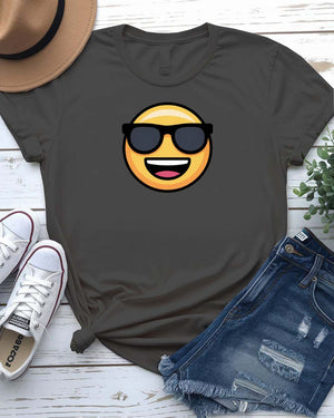 Funny emoji face wearing glasses printed in bold on a unisex t-shirt – shown on smiling model.