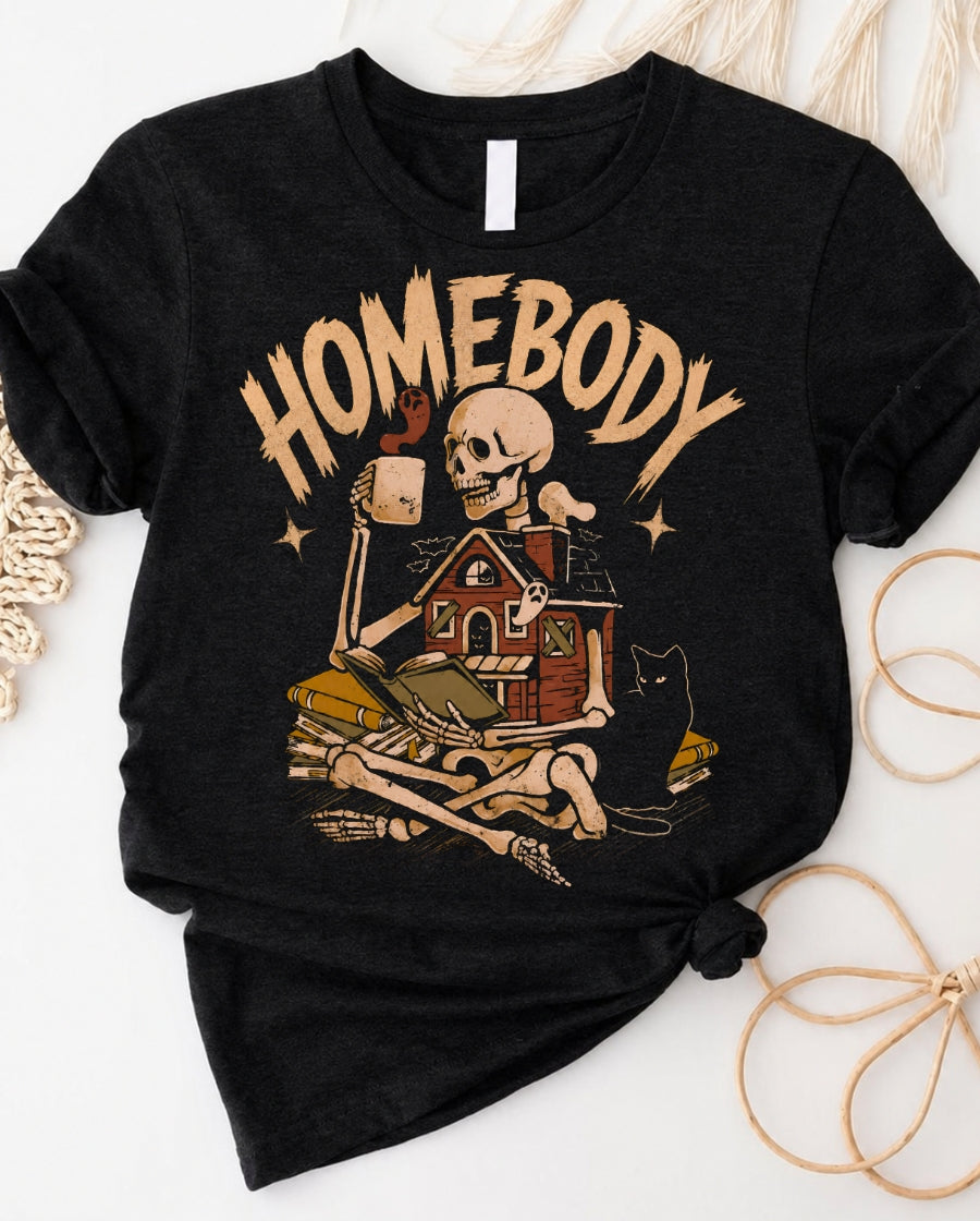 Homebody skeleton t-shirt with cozy skeleton lounging with coffee and book