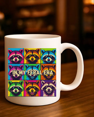 In My Feral Era Raccoon Mug – Funny ceramic coffee cup with chaotic raccoon meme design.