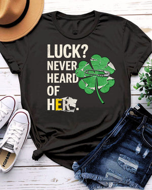 Luck Never Heard of Her St. Patrick's Tee with confident woman walking past clovers on model