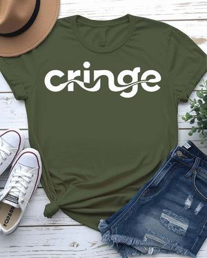 Model wearing the “Cringe” typographical t-shirt in black, smiling awkwardly, styled with denim and sneakers against a neutral background