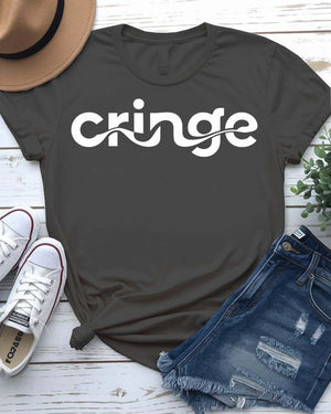 Model wearing the “Cringe” typographical t-shirt in black, smiling awkwardly, styled with denim and sneakers against a neutral background