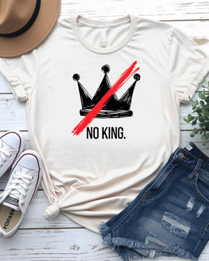 “No King” political meme t-shirt in black with white bold text, displayed on unisex model in urban setting – Memez Store