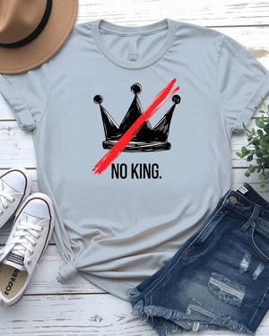 “No King” political meme t-shirt in black with white bold text, displayed on unisex model in urban setting – Memez Store