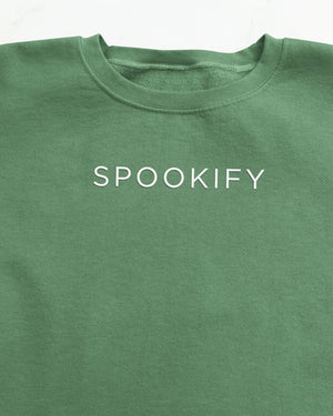 Spookify Halloween embroidered sweatshirt flat lay with pumpkin props.