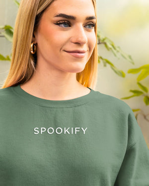 Spookify Halloween embroidered sweatshirt flat lay with pumpkin props.