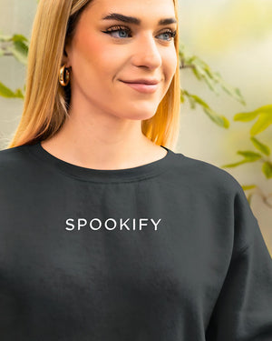 Spookify Halloween embroidered sweatshirt flat lay with pumpkin props.