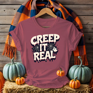 Unisex funny Halloween T-shirt with ghost and pumpkin meme art, laid flat with spooky decor 