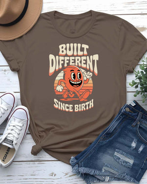 Unisex meme shirt with bold “Built Different Since Birth” typography, styled in casual streetwear.