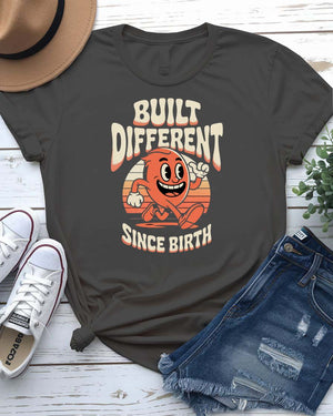 Unisex meme shirt with bold “Built Different Since Birth” typography, styled in casual streetwear.