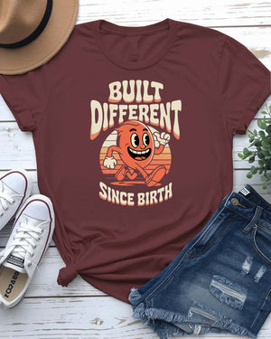 Unisex meme shirt with bold “Built Different Since Birth” typography, styled in casual streetwear.