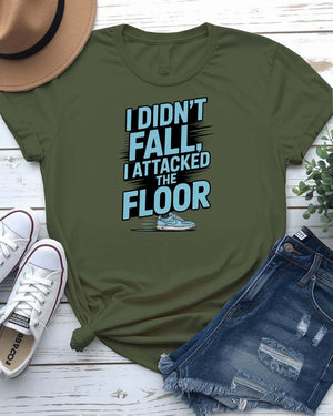 Unisex t-shirt featuring the text “I Didn’t Fall, I Attacked the Floor” in bold, modern typography — perfect for clumsy humor lovers.