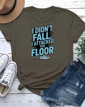 Unisex t-shirt featuring the text “I Didn’t Fall, I Attacked the Floor” in bold, modern typography — perfect for clumsy humor lovers.