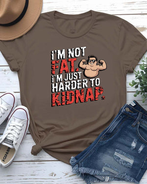 Unisex t-shirt with bold black typography that reads “I Am Not Fat I Am Just Harder to Kidnap” – meme fashion with a body-positive punchline.
