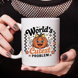 World's Cuttest Problem Halloween Meme Mug on desk with coffee