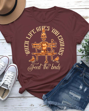 Feed The Bird T-Shirt with hand offering seeds to sparrow on model
