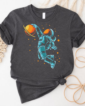 Astronaut playing basketball on moon surface graphic tee