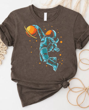 Astronaut playing basketball on moon surface graphic tee