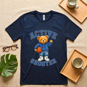 A person wearing a soft gray t-shirt with a vintage-style graphic of a bear wearing a sports headband, against a neutral background.