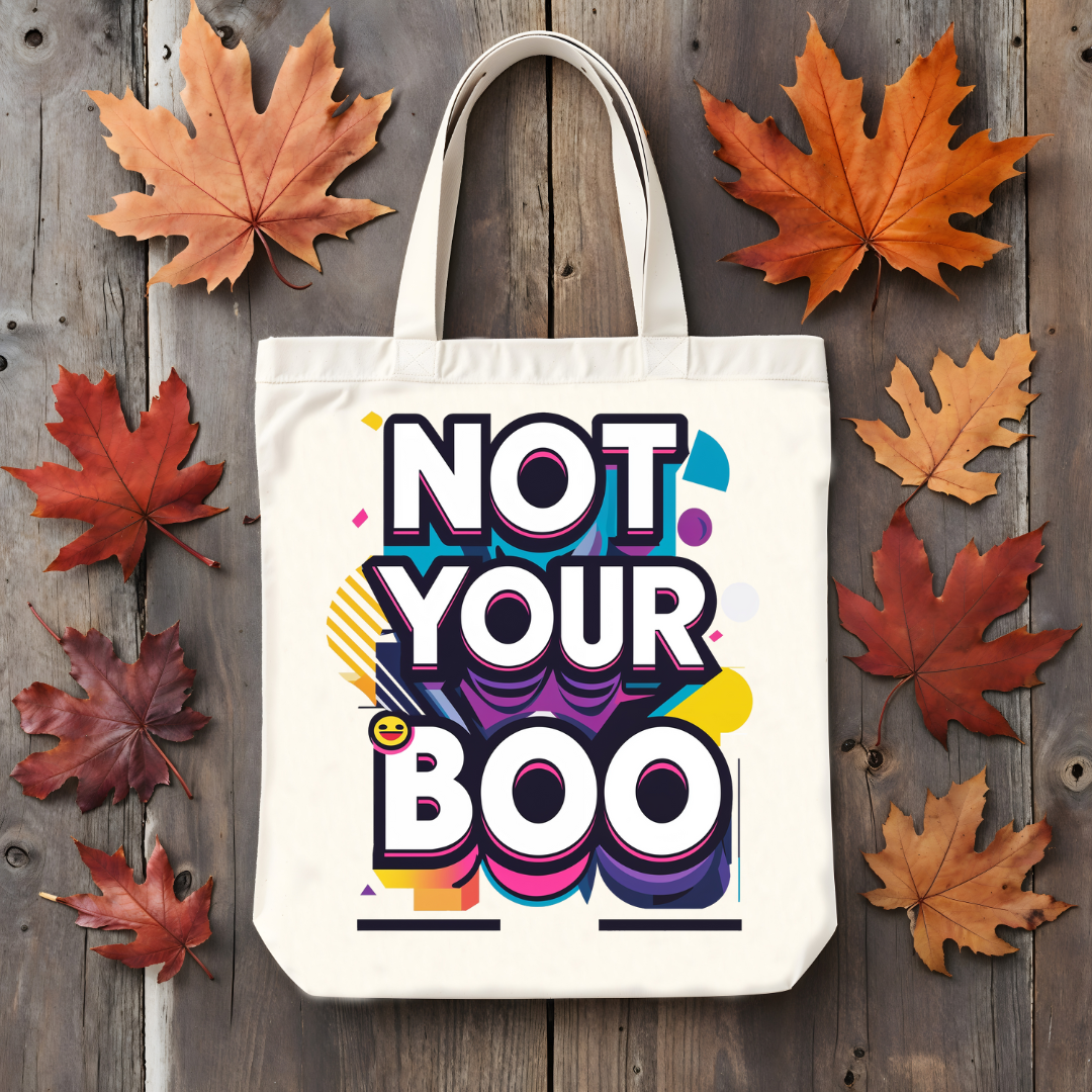 Tote bag with 'Not Your Boo' design on a wooden surface with autumn leaves